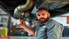 RV maintenance, focused expression, tightening bolts under the chassis, photorealistic, in a spacious garage with tools scattered around, highly detailed, grease stains on overalls, steely silver, harsh fluorescent lighting, shot with a 28mm lens.